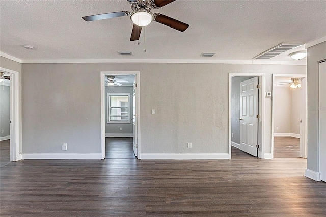 empty room featuring dark hardwood / wood-style floors, ornamental molding, and a textured ceiling