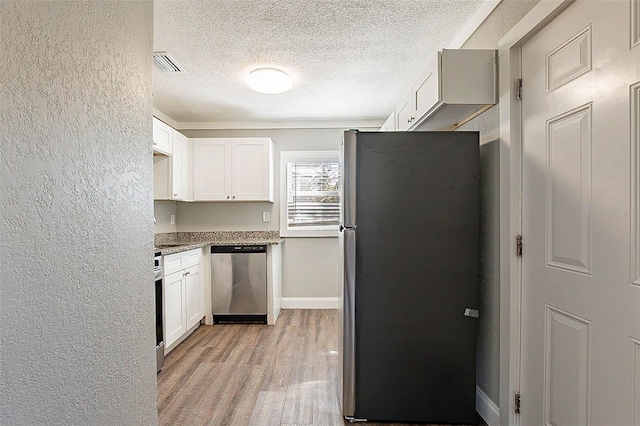 kitchen with white cabinetry, a textured ceiling, appliances with stainless steel finishes, and light hardwood / wood-style flooring