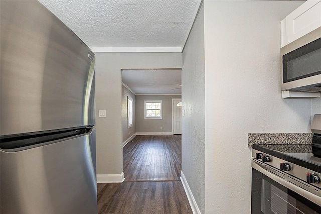 kitchen with white cabinets, dark hardwood / wood-style floors, a textured ceiling, and appliances with stainless steel finishes