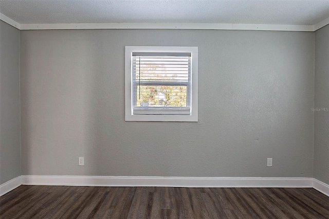 spare room featuring dark hardwood / wood-style floors and ornamental molding