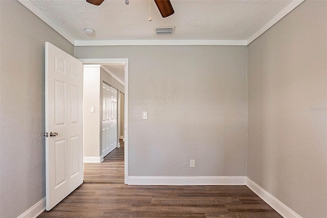 spare room with a textured ceiling, ceiling fan, and dark wood-type flooring