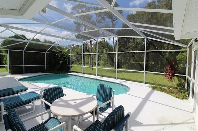 view of pool with a lanai, a patio, and a lawn