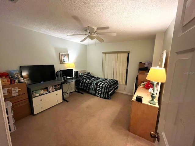 bedroom with light colored carpet, ceiling fan, and a textured ceiling