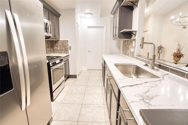 kitchen with pendant lighting, light tile patterned floors, tasteful backsplash, light stone counters, and stainless steel appliances