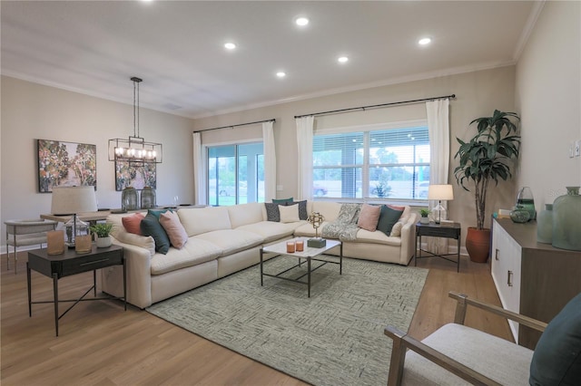 living room with a chandelier, a healthy amount of sunlight, and light wood-type flooring