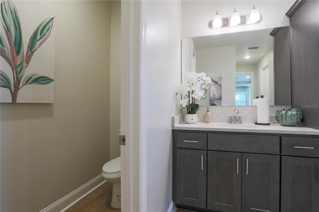 bathroom featuring vanity, wood-type flooring, and toilet