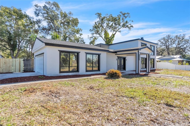 view of front of property featuring a garage and a front lawn