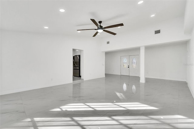 unfurnished room with a towering ceiling, french doors, and ceiling fan