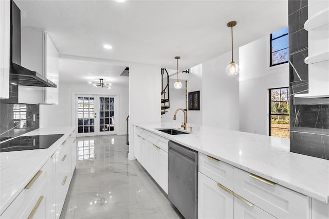 kitchen with decorative light fixtures, white cabinetry, sink, stainless steel dishwasher, and light stone countertops