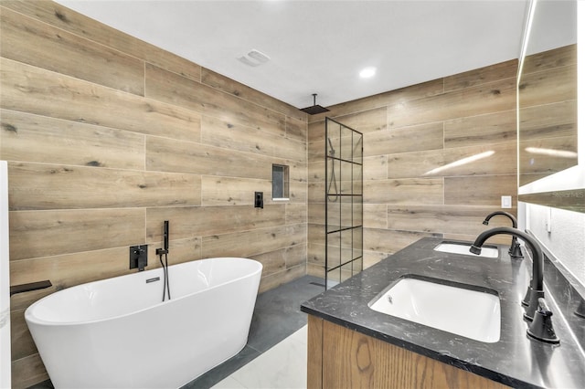 bathroom featuring independent shower and bath, vanity, and wood walls