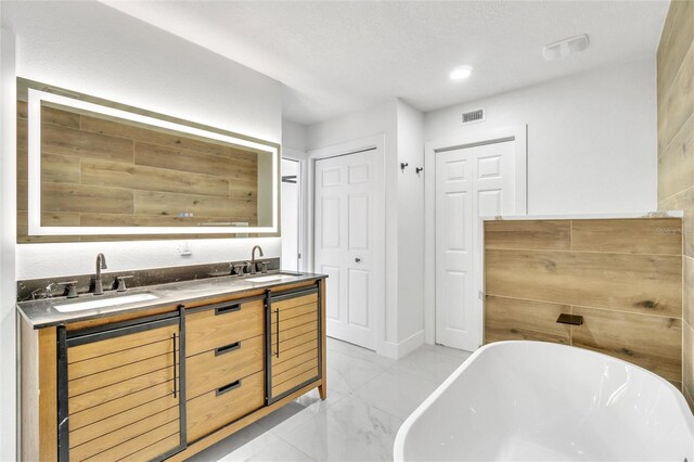 bathroom with a washtub and vanity