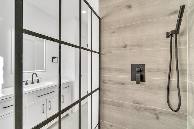 bathroom with vanity and a tile shower