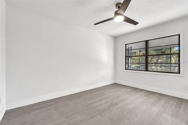 spare room with hardwood / wood-style flooring, ceiling fan, and a textured ceiling