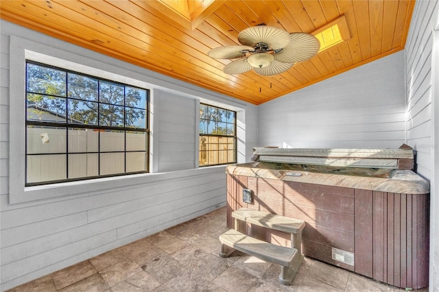 bedroom with vaulted ceiling, ceiling fan, wooden ceiling, and wooden walls