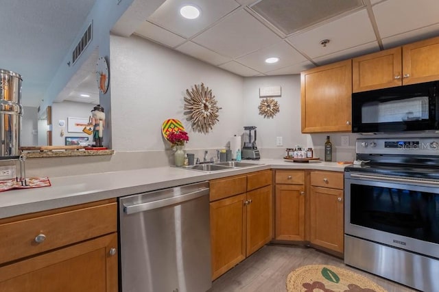 151 E Washington St Unit 201, Orlando, FL 32801 - kitchen with stainless steel appliances, light wood-style flooring, light countertops, recessed lighting, and brown cabinetry