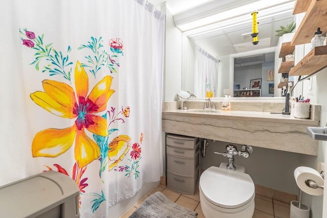 full bathroom featuring tile patterned floors, shower / bath combo with shower curtain, sink, and toilet