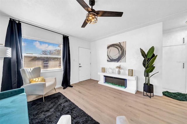 living room with ceiling fan and light hardwood / wood-style flooring