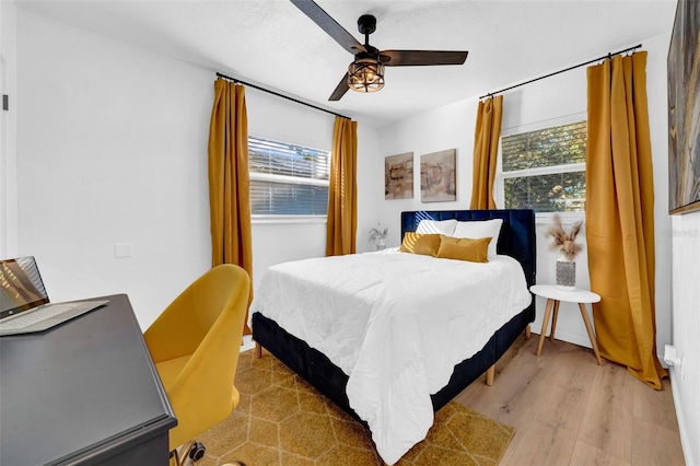 bedroom featuring light hardwood / wood-style flooring, multiple windows, and ceiling fan