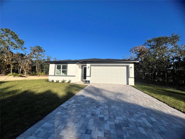 view of front of house with a garage and a front lawn