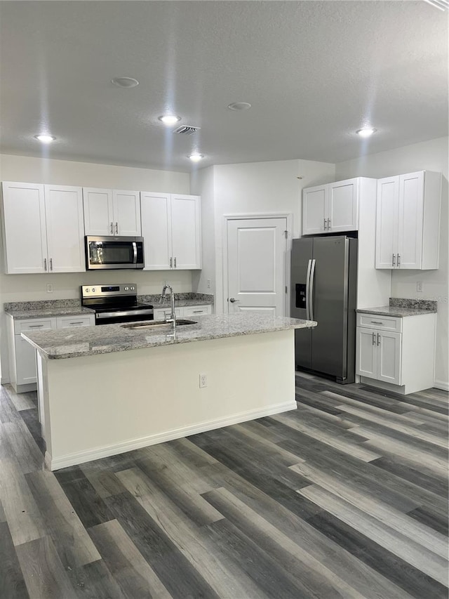 kitchen featuring white cabinets, appliances with stainless steel finishes, dark hardwood / wood-style flooring, and a center island with sink