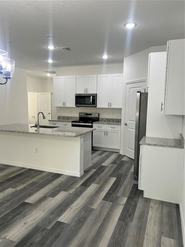 kitchen with white cabinetry, sink, light stone counters, and appliances with stainless steel finishes