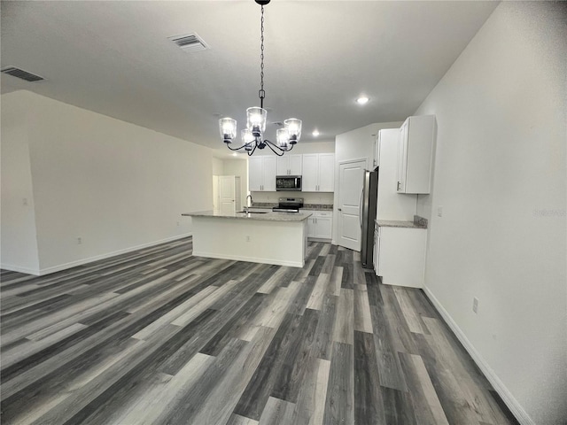 kitchen featuring dark hardwood / wood-style flooring, stainless steel appliances, pendant lighting, white cabinets, and an island with sink