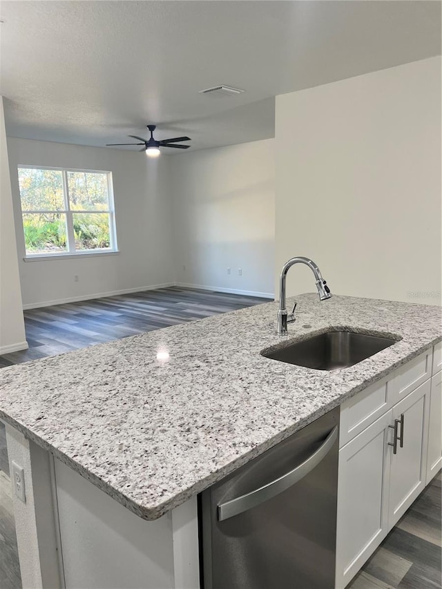 kitchen featuring dark wood-type flooring, sink, stainless steel dishwasher, light stone counters, and white cabinetry