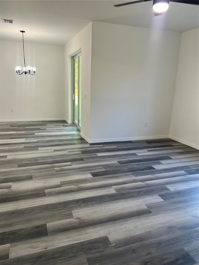 unfurnished room featuring a chandelier and dark wood-type flooring