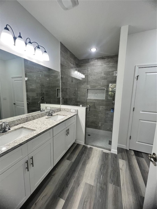 bathroom featuring hardwood / wood-style floors, vanity, and an enclosed shower