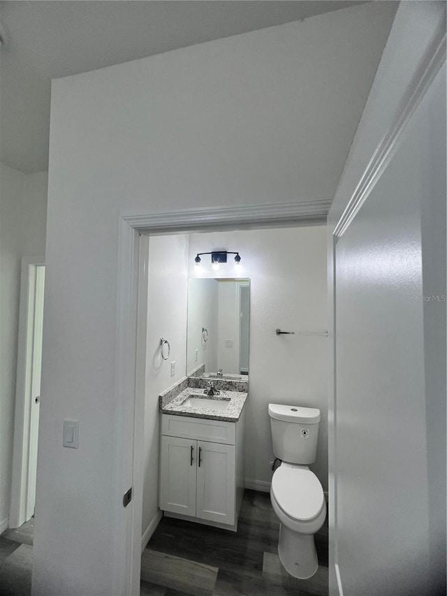 bathroom featuring hardwood / wood-style floors, vanity, and toilet