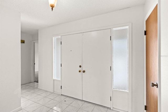 tiled entrance foyer featuring a textured ceiling