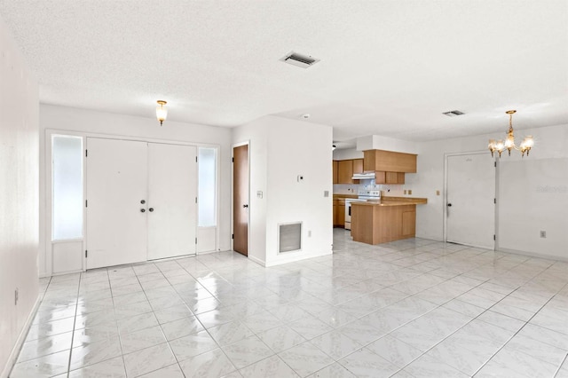 interior space with a textured ceiling and a notable chandelier