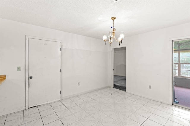 empty room with a textured ceiling and an inviting chandelier