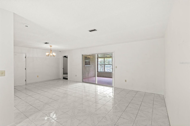 unfurnished room with a chandelier