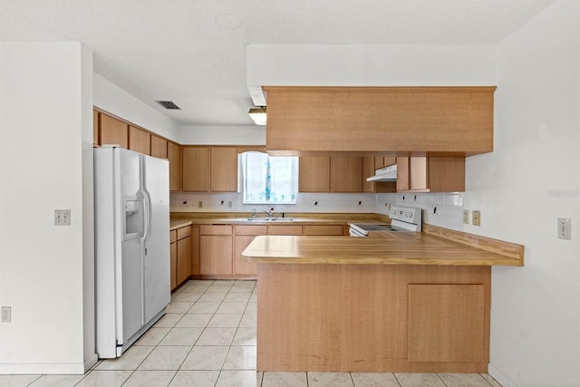 kitchen featuring white appliances, backsplash, sink, light tile patterned floors, and kitchen peninsula