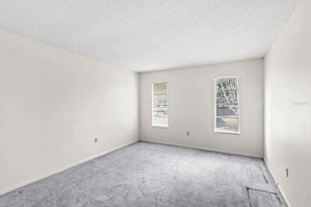 empty room with light carpet and a textured ceiling