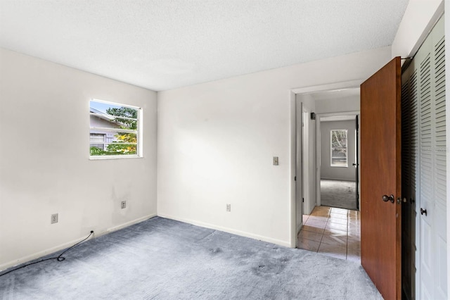 carpeted spare room with a textured ceiling