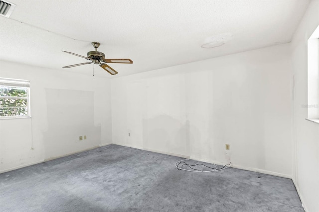 carpeted spare room featuring a textured ceiling and ceiling fan