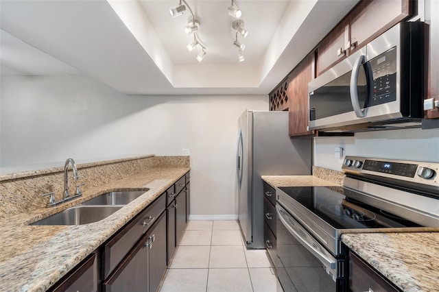 kitchen with light stone countertops, dark brown cabinetry, stainless steel appliances, sink, and light tile patterned floors