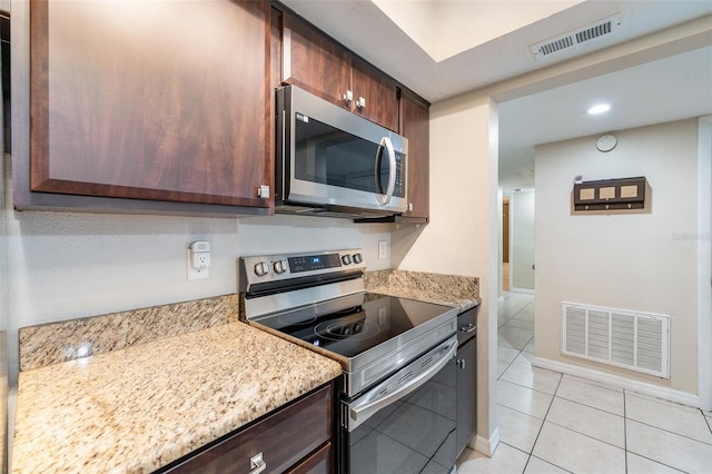 kitchen featuring light stone counters, light tile patterned floors, and appliances with stainless steel finishes