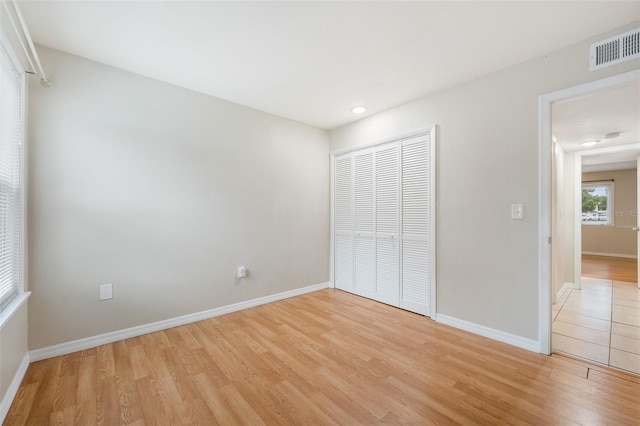 unfurnished bedroom featuring light wood-type flooring and a closet