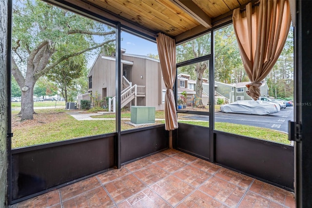 unfurnished sunroom featuring beam ceiling and wood ceiling