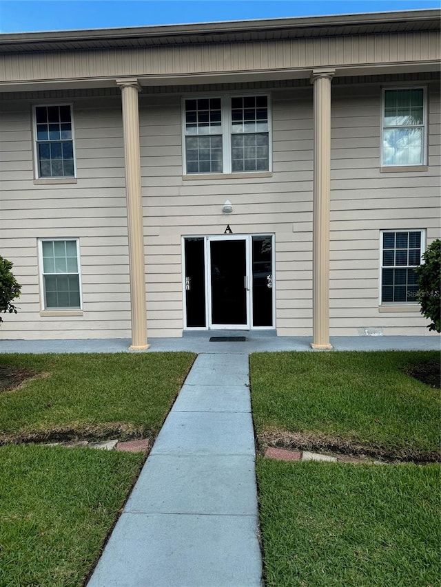 view of exterior entry with a yard