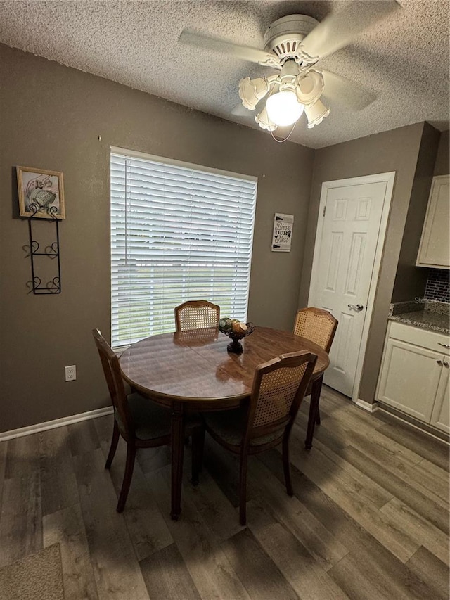 dining space featuring a textured ceiling, dark hardwood / wood-style flooring, and ceiling fan