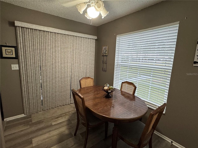 dining room with dark hardwood / wood-style floors, ceiling fan, plenty of natural light, and a textured ceiling