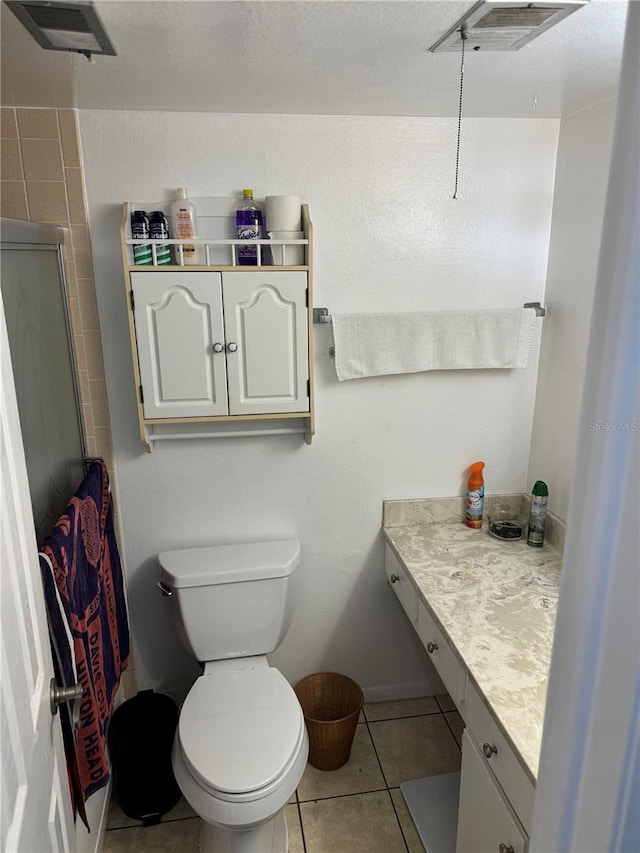 bathroom with tile patterned floors, walk in shower, vanity, and toilet