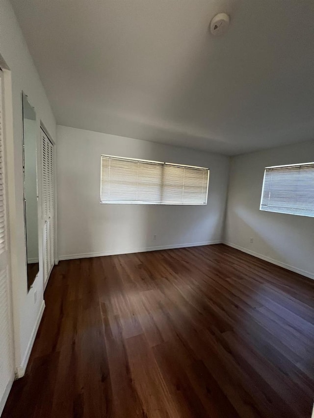 unfurnished room with dark wood-type flooring