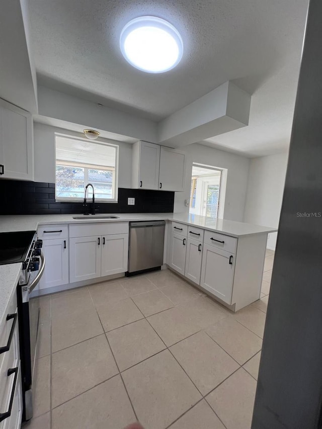 kitchen featuring white cabinets, stainless steel appliances, kitchen peninsula, and sink