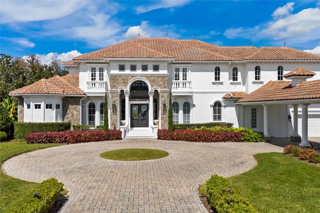 mediterranean / spanish house with french doors and a balcony