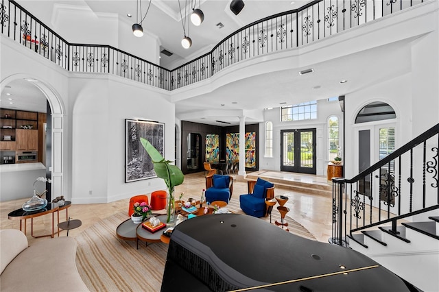 entrance foyer with ornamental molding, a high ceiling, and french doors